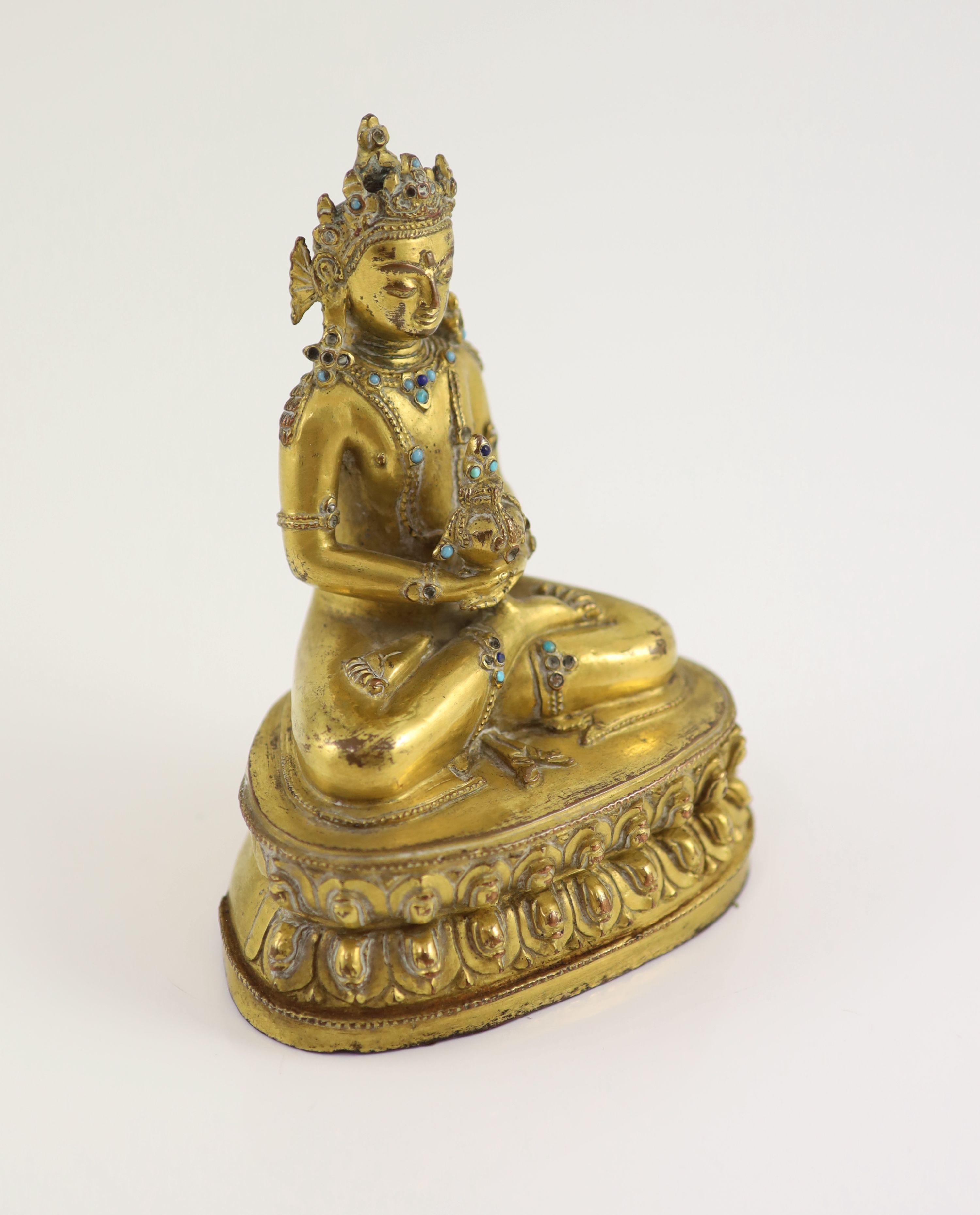 A Tibetan gilt copper alloy seated figure of Amitayus, probably 15th/16th century, 15cm high